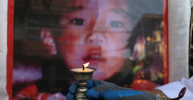 A Tibetan woman living in exile and a member of the Tibetan Women's Association lights a butter lamp during an event to mark the 31st birthday of Panchen Lama in McLeod Ganj, near Dharamsala, India, April 25, 2020.(EPA Photo)