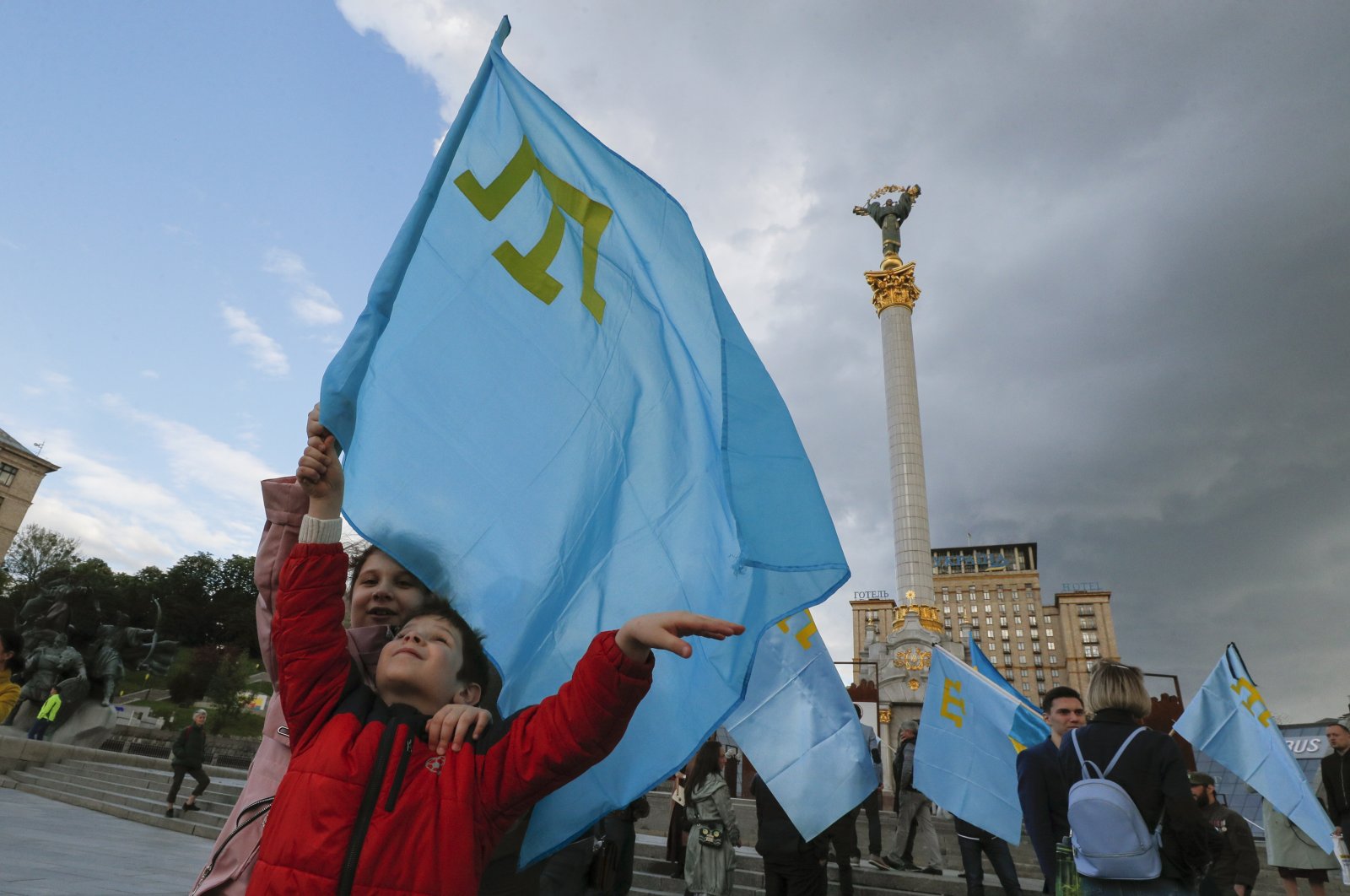 Crimean Tatars hold flags during a commemoration meeting on Independence Square in Kyiv, Ukraine, May 18, 2020. (EPA Photo)
