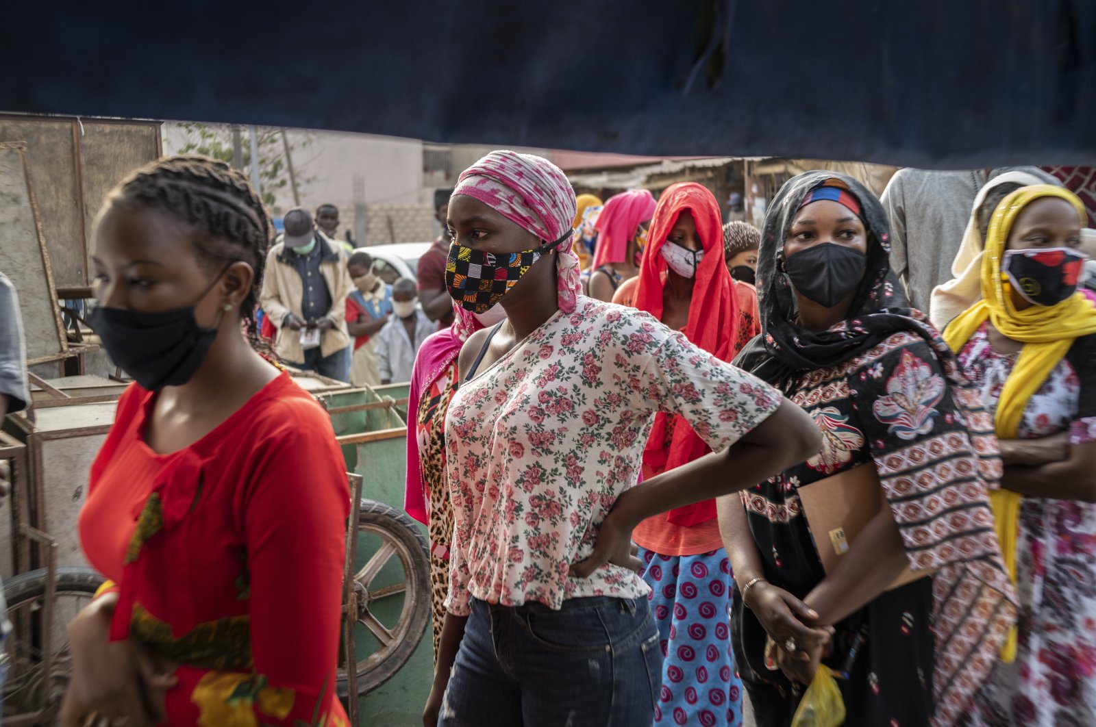 Women wear face masks as they queue to buy bread on the first day of the Muslim fasting month of Ramadan, in Dakar, Senegal, April 25, 2020. (AP Photo)