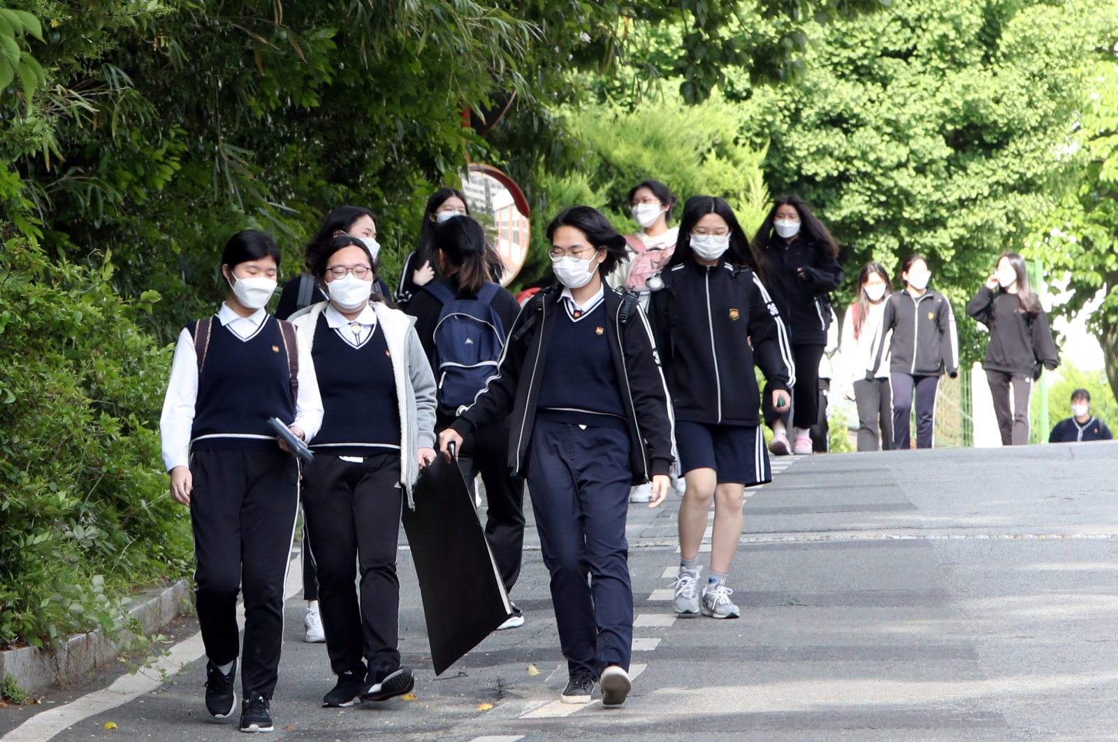 High school students wearing protective masks walk after finishing their classes, as schools reopen following the global outbreak of COVID-19, Gwangju, South Korea, May 20, 2020. (Yonhap via Reuters Photo)