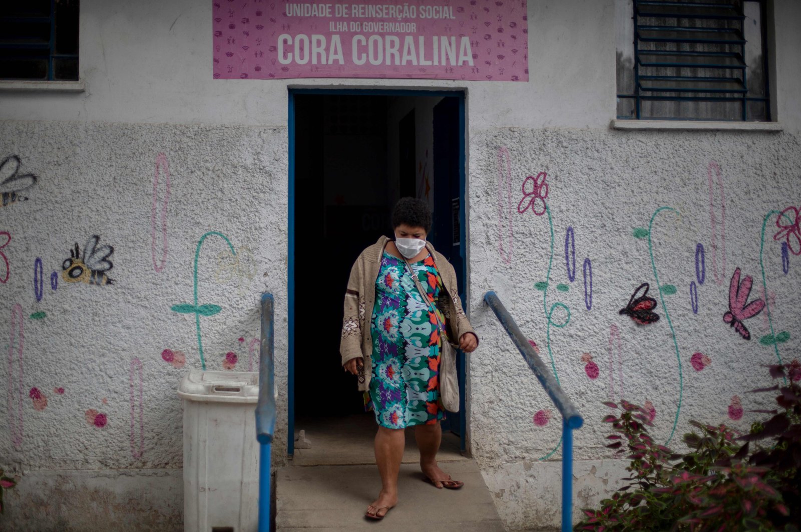 A resident of the public shelter goes out of a dormitory while Brazil's Armed Forces soldiers disinfect the place at the Ilha do Governador neighborhood, Rio de Janeiro, May 14, 2020. (AFP Photo)