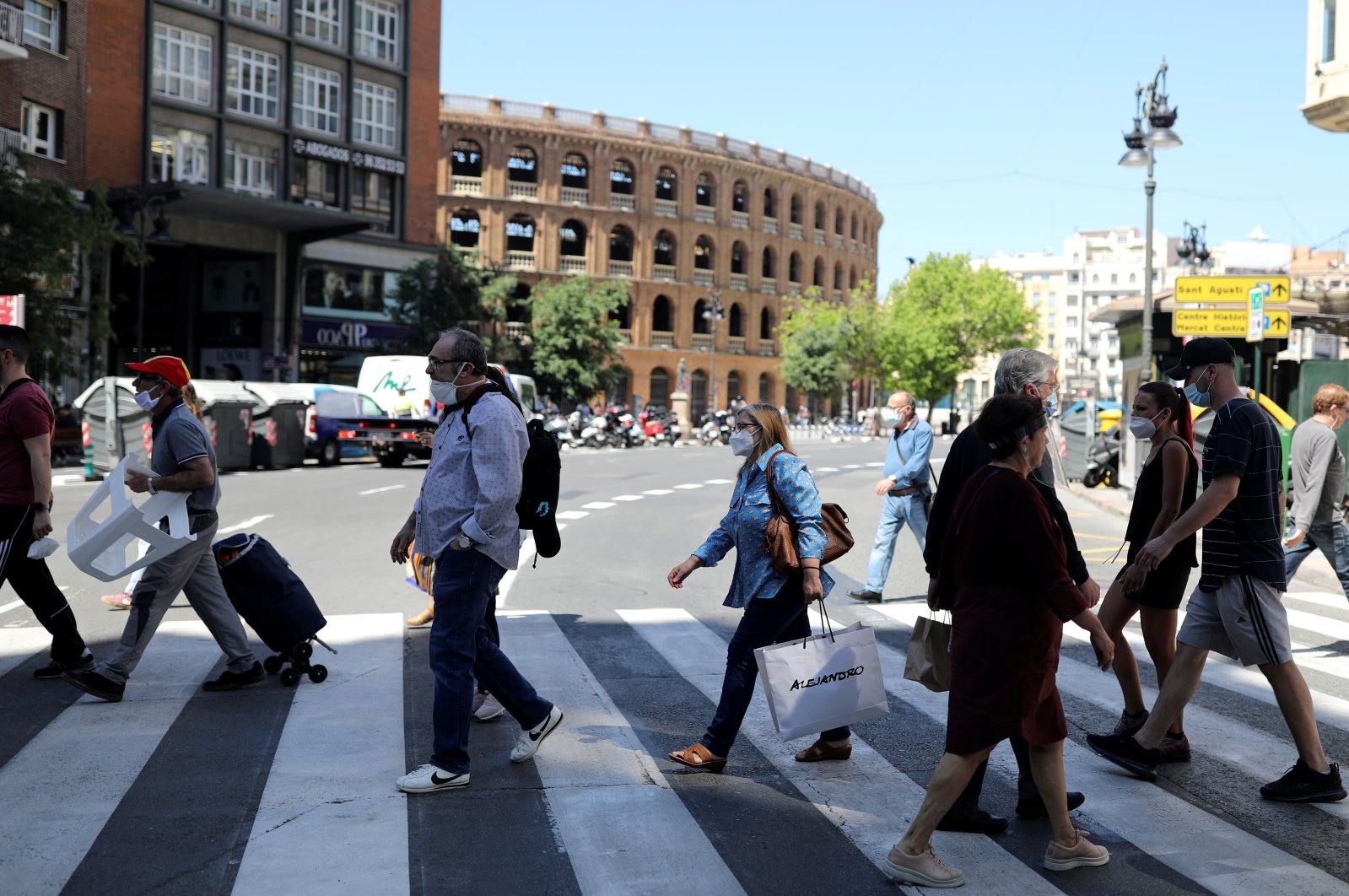 People wearing face masks walk on a crosswalk, as some Spanish provinces are allowed to ease lockdown restrictions during phase one, amid the coronavirus outbreak, in Valencia, Spain, May 19, 2020. (Reuters Photo)
