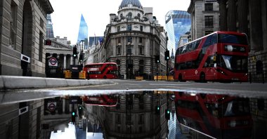 Red buses pass the Bank of England in the financial district of London, May 14, 2020. (EPA Photo)