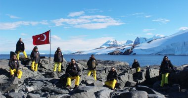 Turkish scientists pose next to a Turkish flag in this undated photo from their first Antarctica expedition in 2016. (İHA Photo)