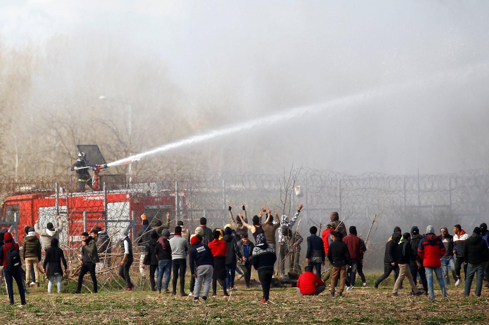 A Greek firefighter uses a water cannon as migrants gather on the Turkish-Greek border near Turkey's Pazarkule border crossing with Greece's Kastanies, in Edirne, Turkey, March 7, 2020. (Reuters File Photo)