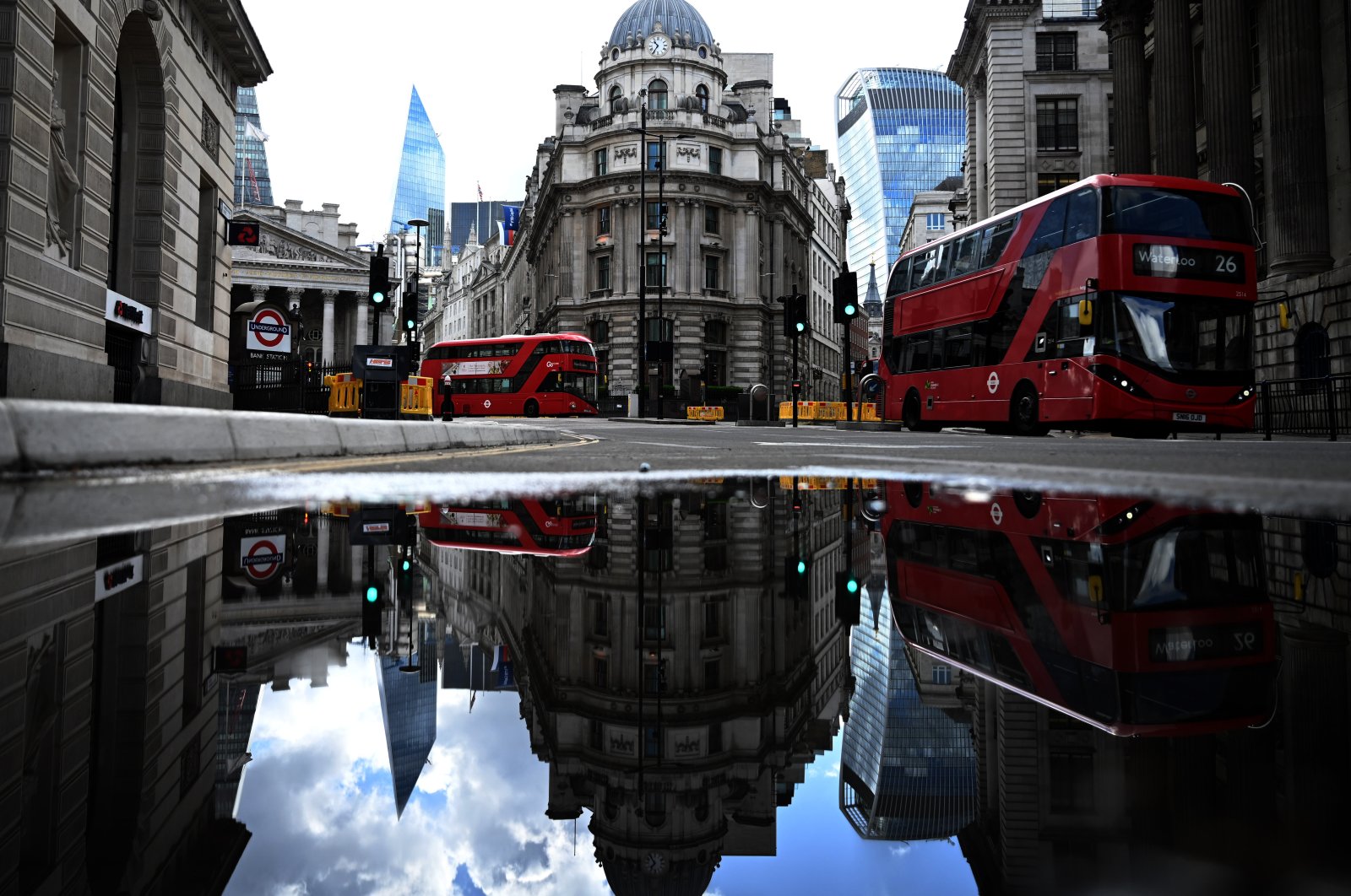 Red buses pass the Bank of England in the financial district of London, May 14, 2020. (EPA Photo)
