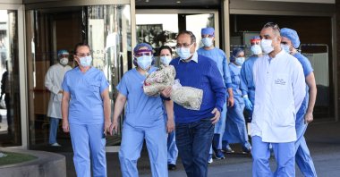Hospital staff cheer as pulmonologist professor Bülent Tutluoğlu leaves a hospital following his COVID-19 treatment, Istanbul, Turkey, April 14, 2020. (AA Photo)
