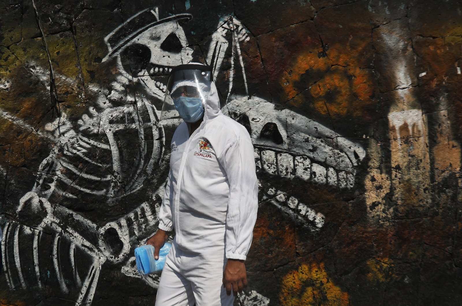 A municipal worker carries face masks to hand out at the San Nicolas Tolentino Pantheon that is making space for more burials amid the COVID-19 pandemic in the Iztapalapa area of Mexico City, Friday, May 22, 2020. (AP Photo)