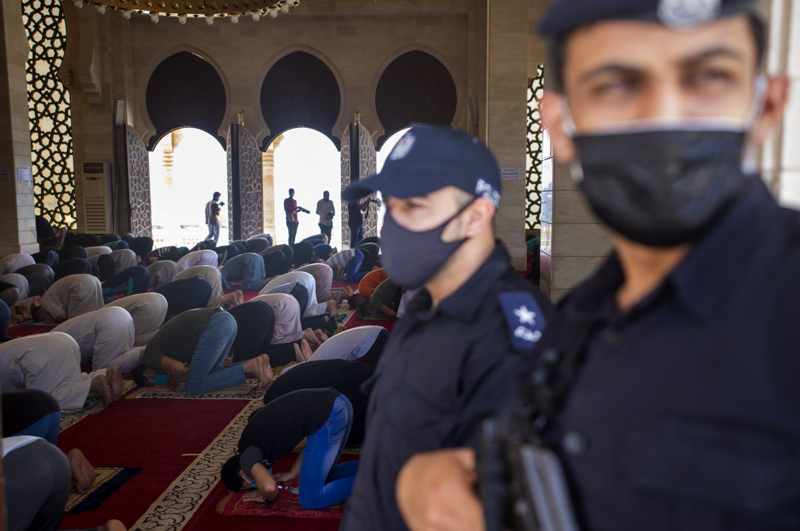 Palestinian Hamas police stand guard at the entrance of a mosque as worshipers attend the last Friday noon prayer of the holy month of Ramadan, Gaza City, Friday, May. 22, 2020. The blockaded territory confirmed its first COVID-19 death on Saturday.