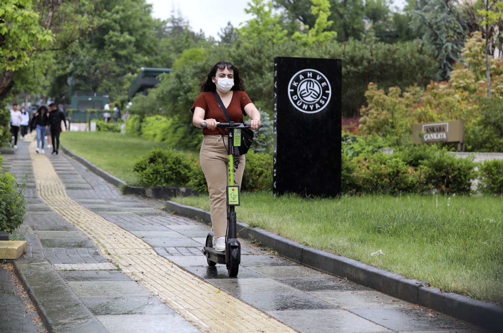 A woman wearing a face mask for protection against the new coronavirus, rides a scooter just hours before a four-day new curfew declared by the government in an attempt to control the spread of coronavirus, in Ankara, Turkey, Friday, May 22, 2020. (AP Photo)