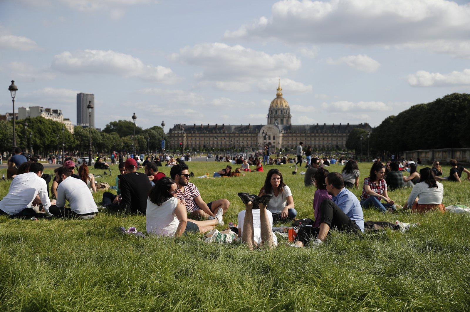 Parisians relax in the non-mowed lawn next to the Invalides Museum in Paris, Sunday, May 24, 2020 as France gradually lifts its COVID-19 lockdown. (AP Photo)