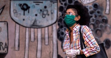 A woman wearing a face mask and gloves walks along a street in Havana, Cuba, May 25, 2020. (AFP Photo)