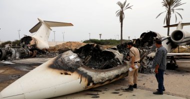 A policeman and a man inspect a passenger plane damaged by shelling at Mitiga airport, Tripoli, Libya May 10, 2020. (Reuters File Photo)