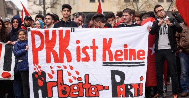 People hold a banner reading "PKK is not a workers party" during a "Peace March for Turkey" organized by the New German Turkish Committee, April 10, 2016. (AFP Photo)