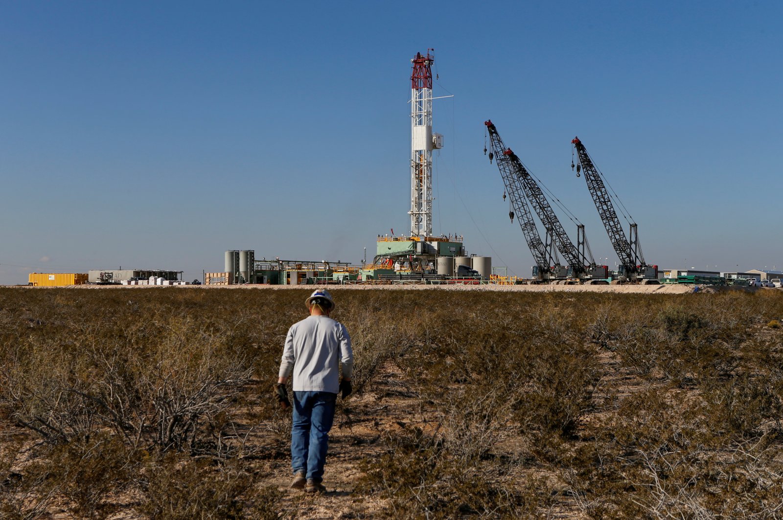 An oil worker walks toward a drill rig after placing ground monitoring equipment in the vicinity of the underground horizontal drill in Loving County, Texas, U.S., Nov. 22, 2019. (Reuters Photo)
