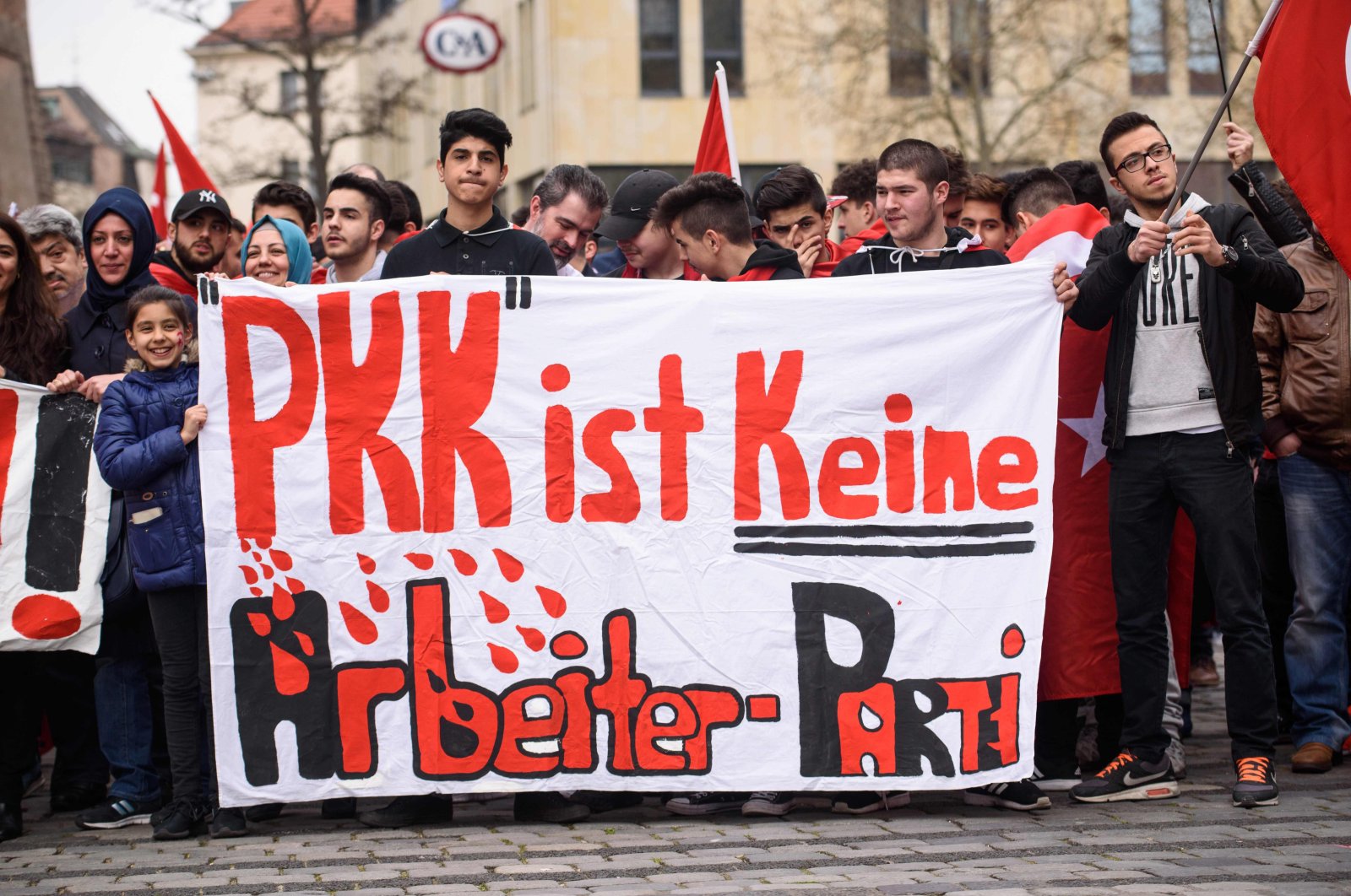 People hold a banner reading "PKK is not a workers party" during a "Peace March for Turkey" organized by the New German Turkish Committee, April 10, 2016. (AFP Photo)