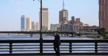 A mask-clad man walks along the Kasr el-Nil bridge connecting the island district of Zamalek to the city center of Cairo, May 24, 2020. (AFP Photo)