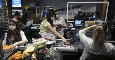People wearing face masks shop for food at a grocery store hours before a four-day curfew, Ankara, Turkey, May 22, 2020. (AP Photo)