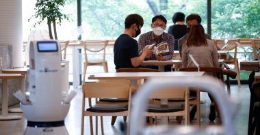 Customers wait at a cafe where a robot that takes orders, makes coffee and brings the drinks straight to customers is being used in Daejeon, South Korea, May 25, 2020. (Reuters Photo)