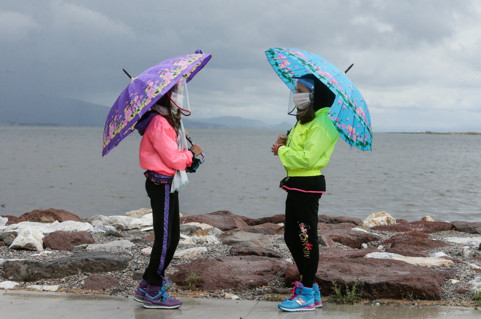 Two girls with umbrellas converse while observing social distancing rules in western Izmir province, Turkey, May 27, 2020. (AA Photo)
