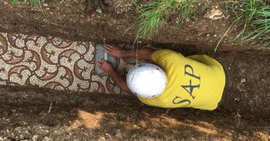 An archaeologist uncovers an ancient Roman mosaic floor discovered under vines in Negrar, near Verona, May 20, 2020. (AFP Photo)