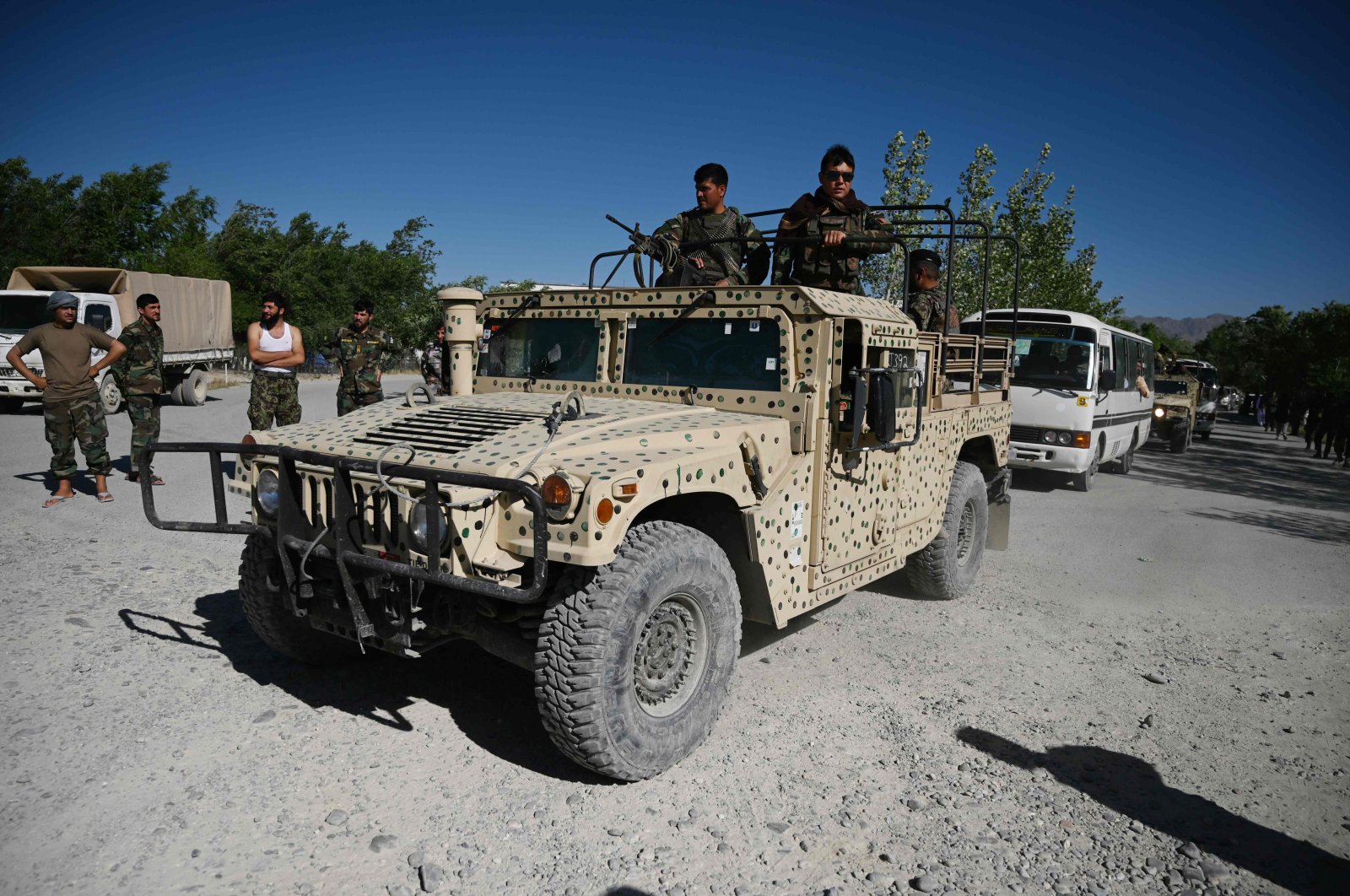 Afghan National Army (ANA) soldier escorts Taliban prisoners convoy during their release from the Bagram prison, in outside of the US military base in Bagram, some 50 km north of Kabul on May 26, 2020. (AFP Photo)