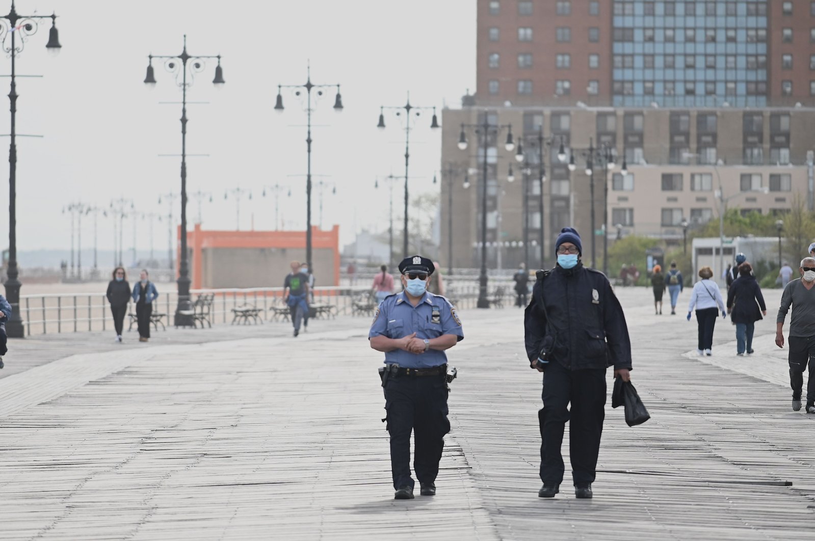 Policemen wearing masks patrol at the promenade at Coney Island Beach on May 18, 2020 in New York City. (AFP Photo)