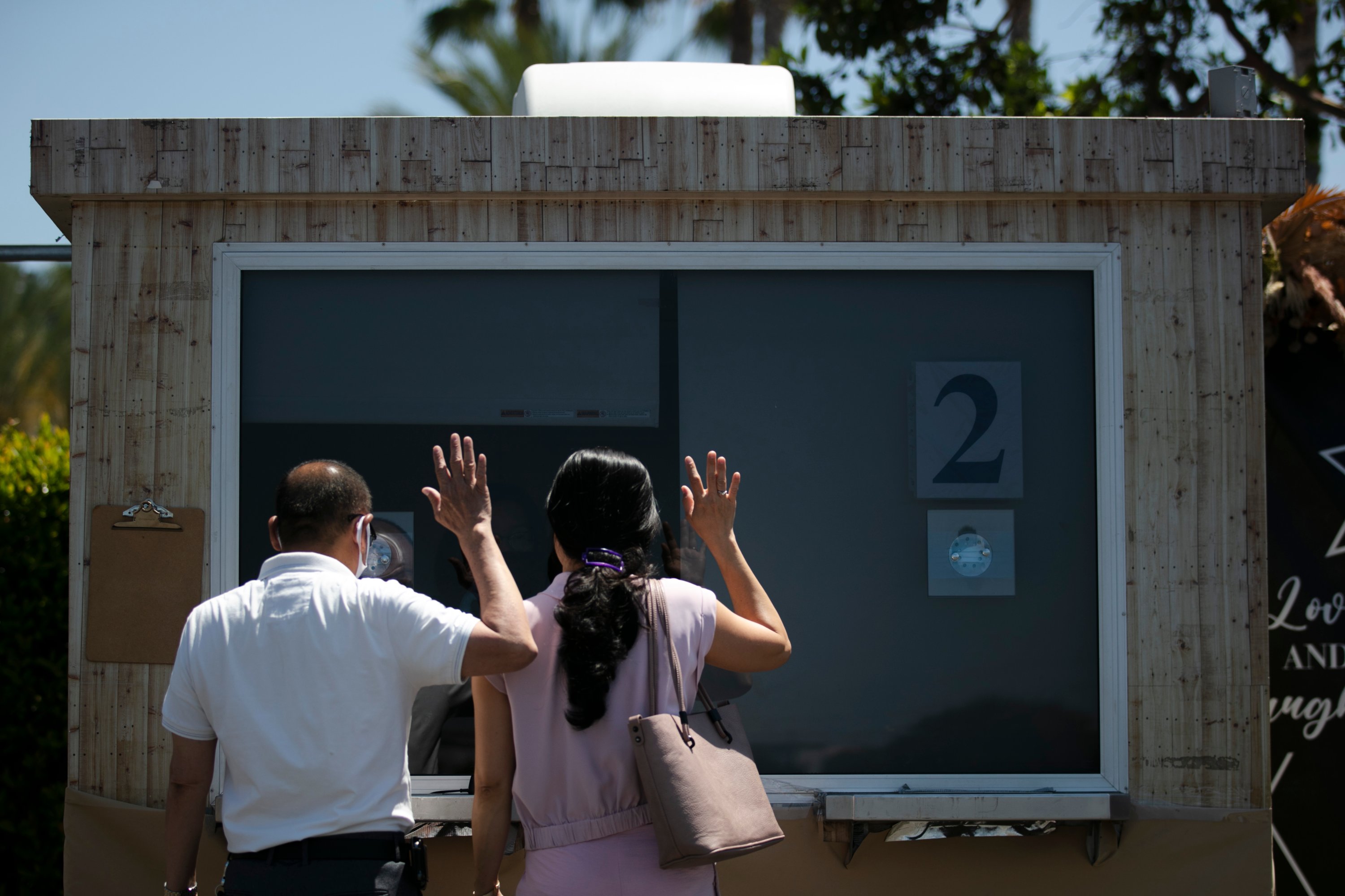 A bride and groom attest to the accuracy of the information they had provided, during their marriage service in the parking lot of the Honda Center in Anaheim, Calif., Tuesday, May 26, 2020. (AP Photo)