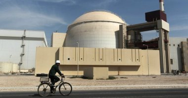 In this Oct. 26, 2010, file photo, a worker rides a bicycle in front of the reactor building of Bushehr Nuclear Power Plant, just outside the southern city of Bushehr, Iran. (AP Photo)