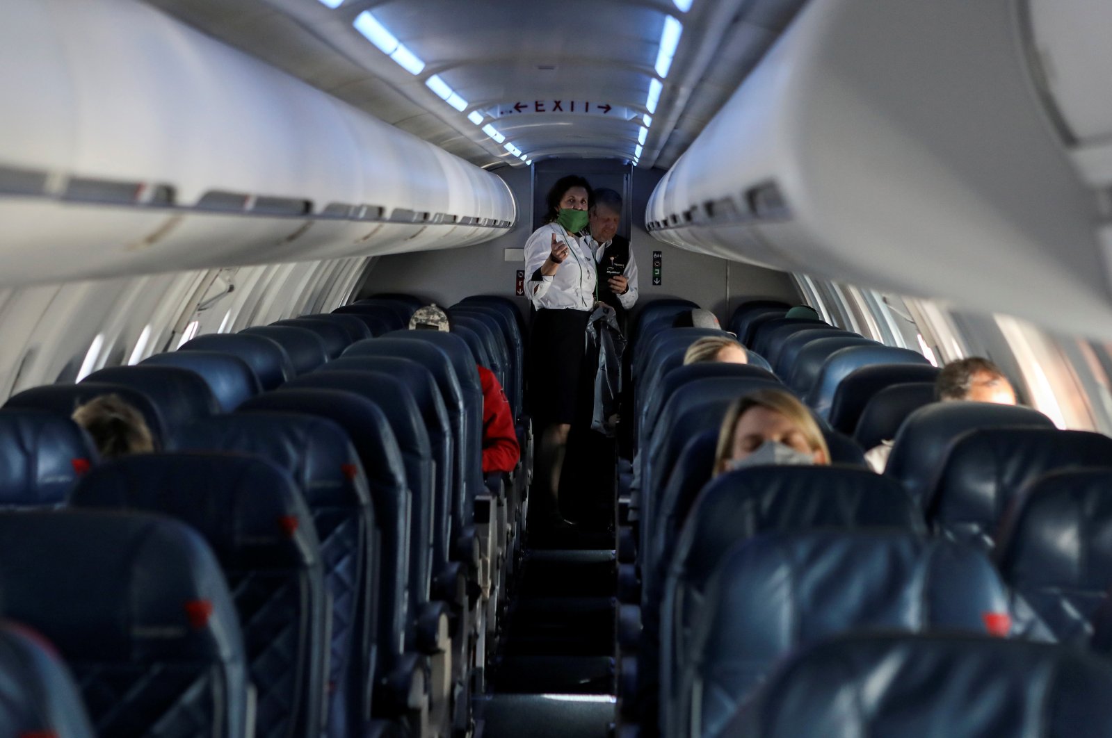 Flight attendants talk in a nearly empty cabin on a Delta Airlines flight operated by SkyWest Airlines as travel has cutback, amid concerns of the coronavirus during a flight departing from Salt Lake City, Utah, U.S., April 11, 2020. (REUTERS Photo)
