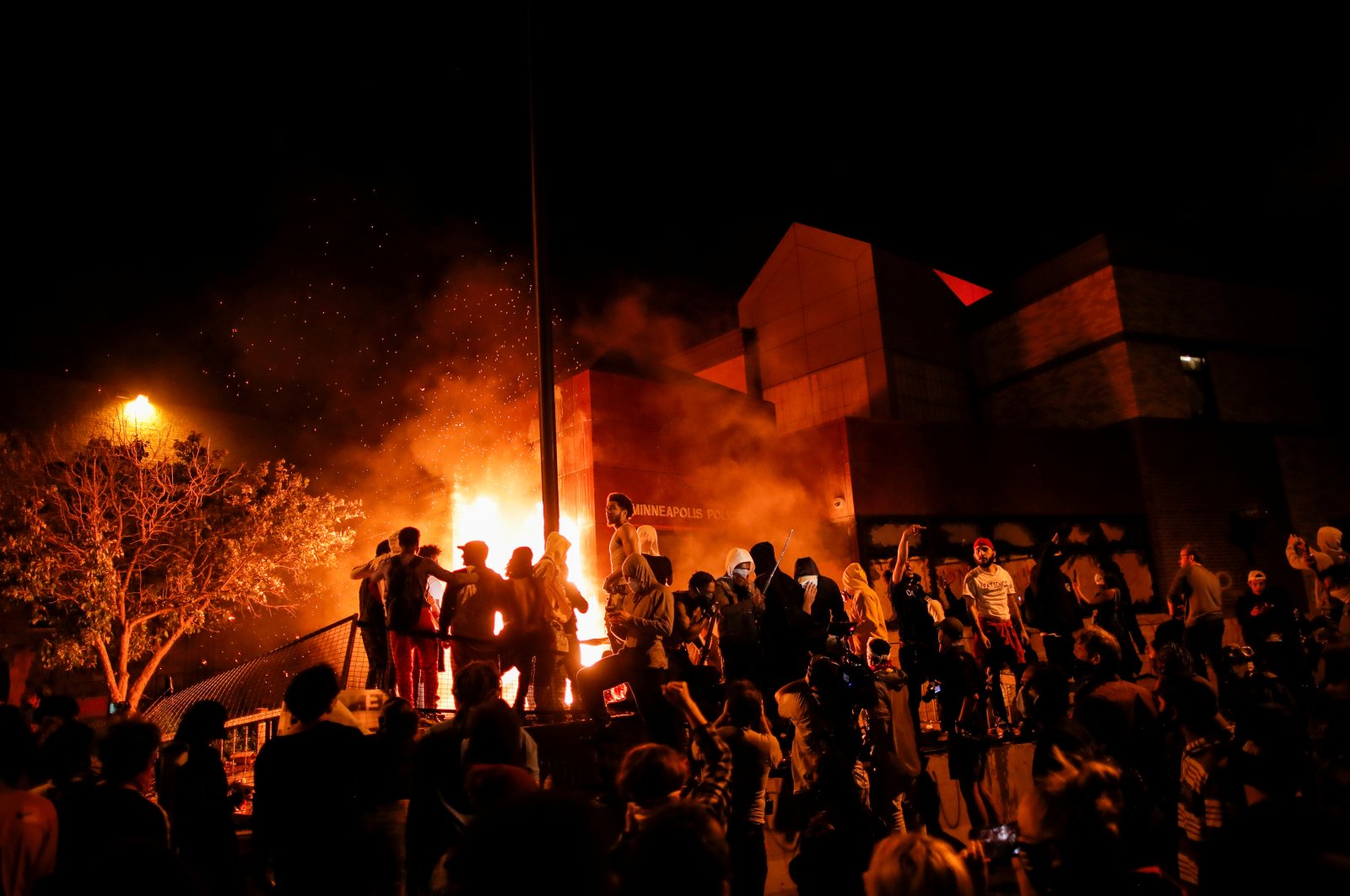 Protesters gather around after setting fire to the entrance of a police station as demonstrations continue after a white police officer was caught on a bystander's video pressing his knee into the neck of African-American man George Floyd, who later died at a hospital, in Minneapolis, Minn., May 28, 2020. (Reuters Photo)