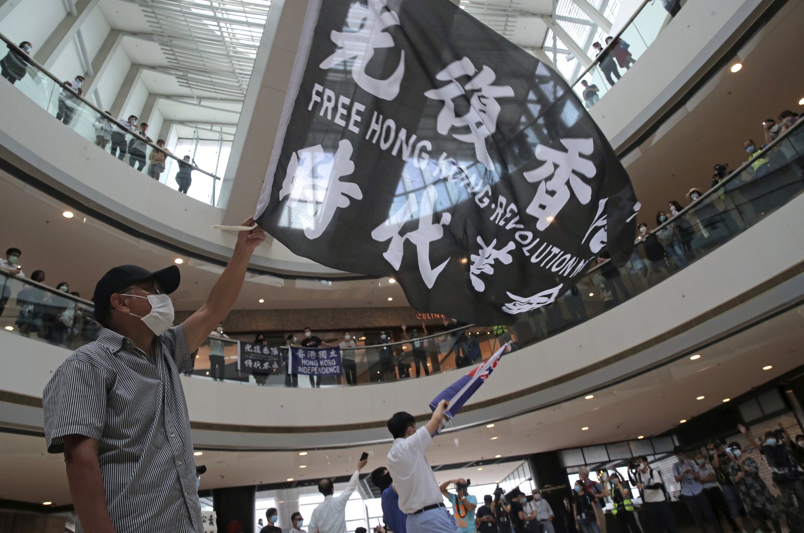 Protesters wave flags in a shopping mall during a protest against China's national security legislation for the city, in Hong Kong, Friday, May 29, 2020. (AP Photo)