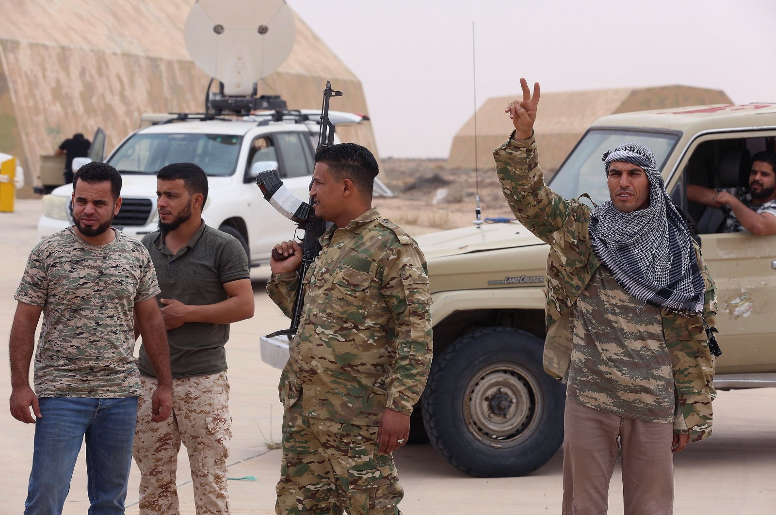 Fighters loyal to Libya's UN-recognised Government of National Accord (GNA) stand outside a hangar at Al-Watiya airbase, which they seized control of, southwest of the capital Tripoli, May 18, 2020. (AFP)