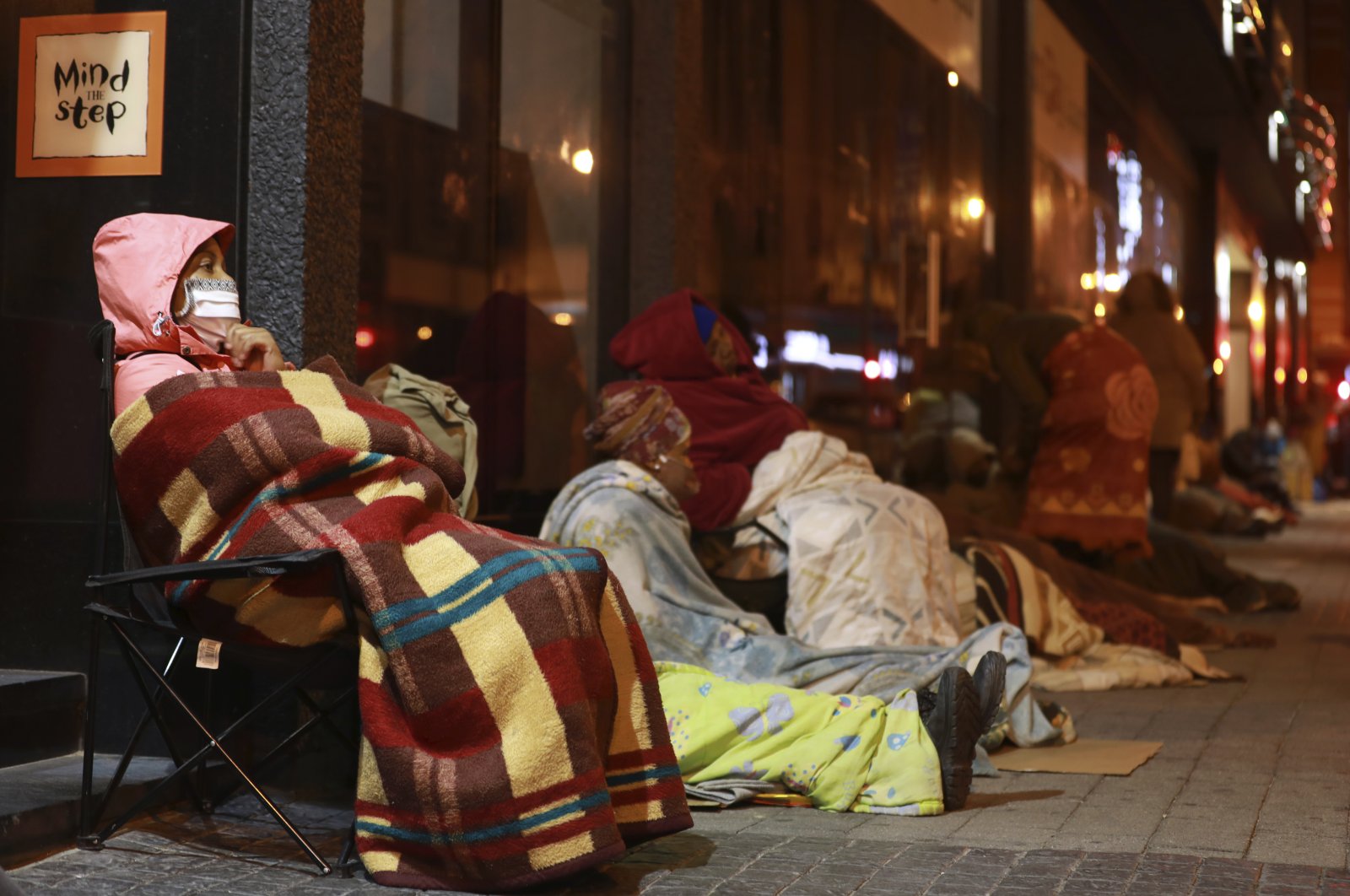 Women who had queued overnight to apply for government grants wait for the offices to open Thursday morning, Cape Town, South Africa, May 28, 2020. (AP Photo)