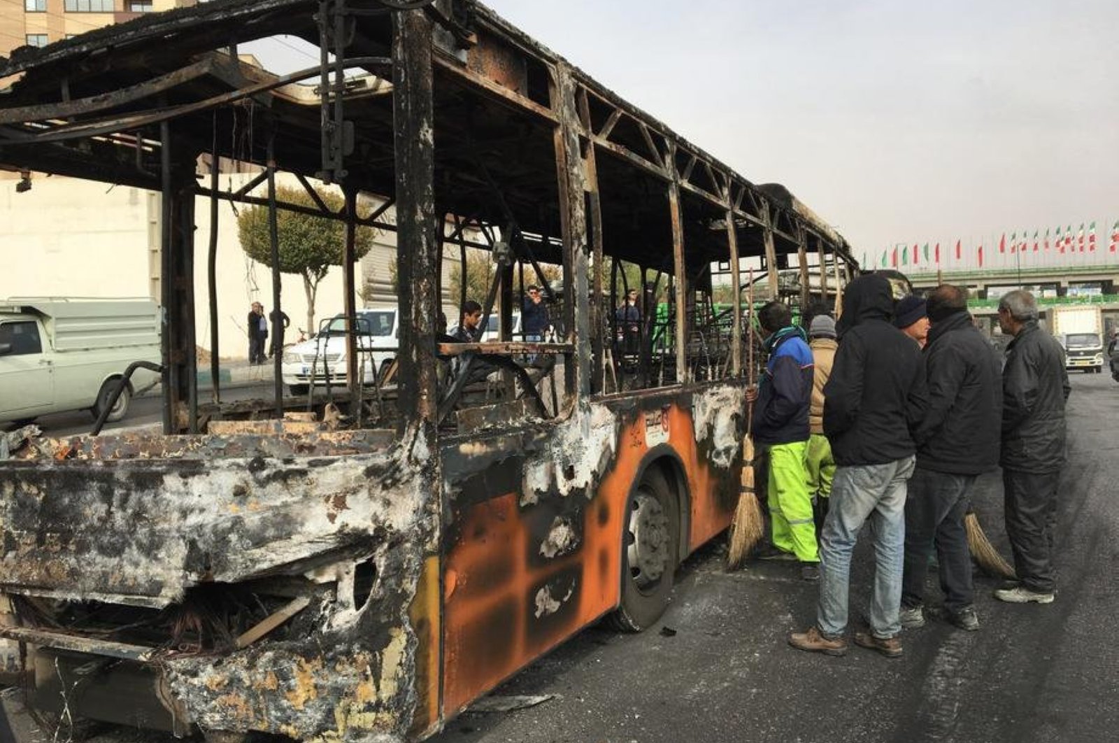 People gather around the wreckage of a public transportation bus that was burnt overnight during the protests over increasing fuel prices, Isfahan, central Iran, Nov. 17, 2019. (EPA-EFE Photo)