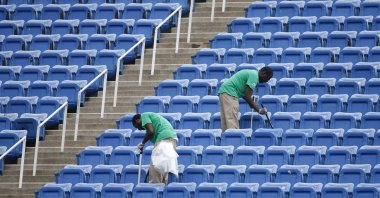 Workers clean the empty stands in Arthur Ashe Stadium after the women's semifinal matches were postponed because of rain at the U.S. Open tennis tournament in New York, U.S., Sept. 10, 2015. (AP Photo) 