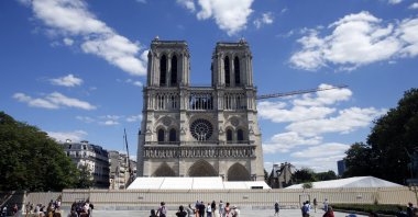 People walk in the forecourt of Notre Dame Cathedral, in Paris, Sunday, May 31, 2020. (AP Photo)