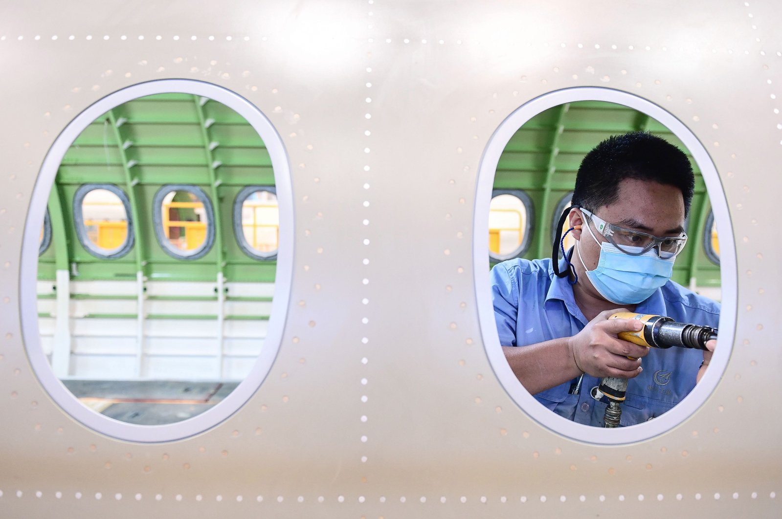 A Chinese employee works on the interior of an Airbus A220 aircraft at a factory in Shenyang in China's northeastern Liaoning province, May 25, 2020. (AFP Photo)