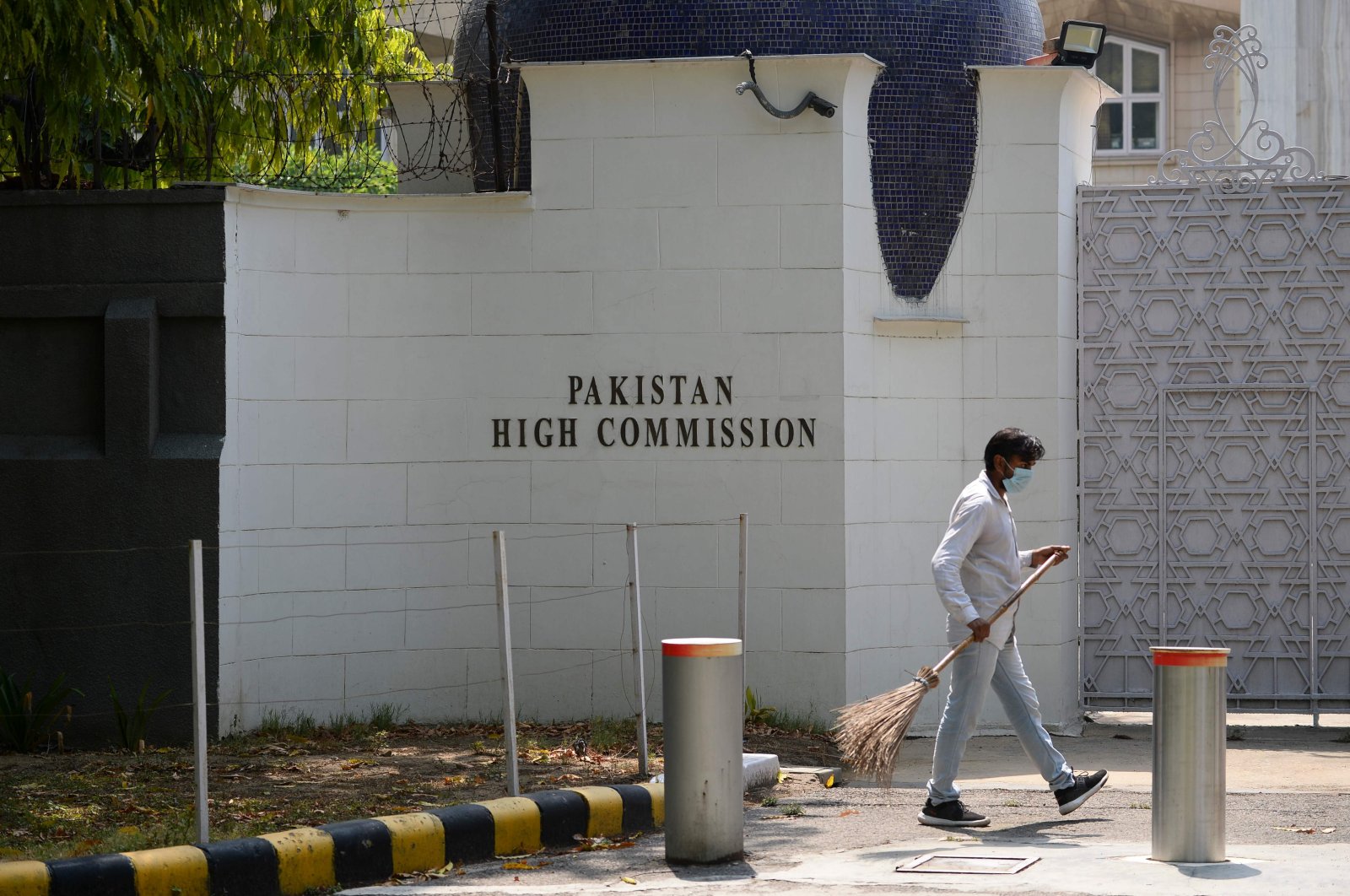 A man sweeps in front of the main gate of the Pakistan High Commission, New Delhi, June 1, 2020. (AFP Photo)