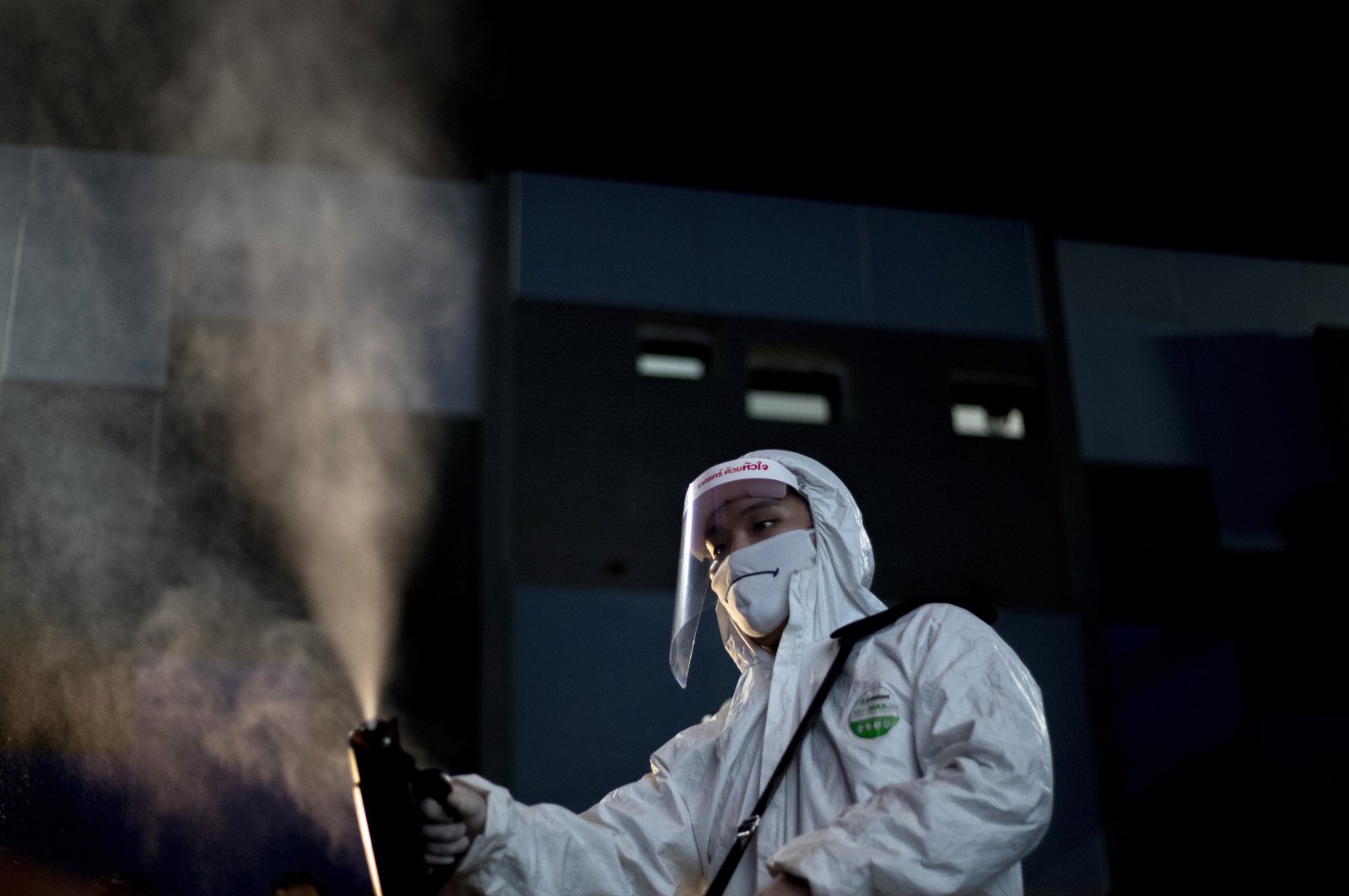 An employee sprays disinfectant as a precaution against the coronavirus at the Paragon Cineplex movie theater in Bangkok, Thailand, Monday, June 1, 2020. (AP Photo)