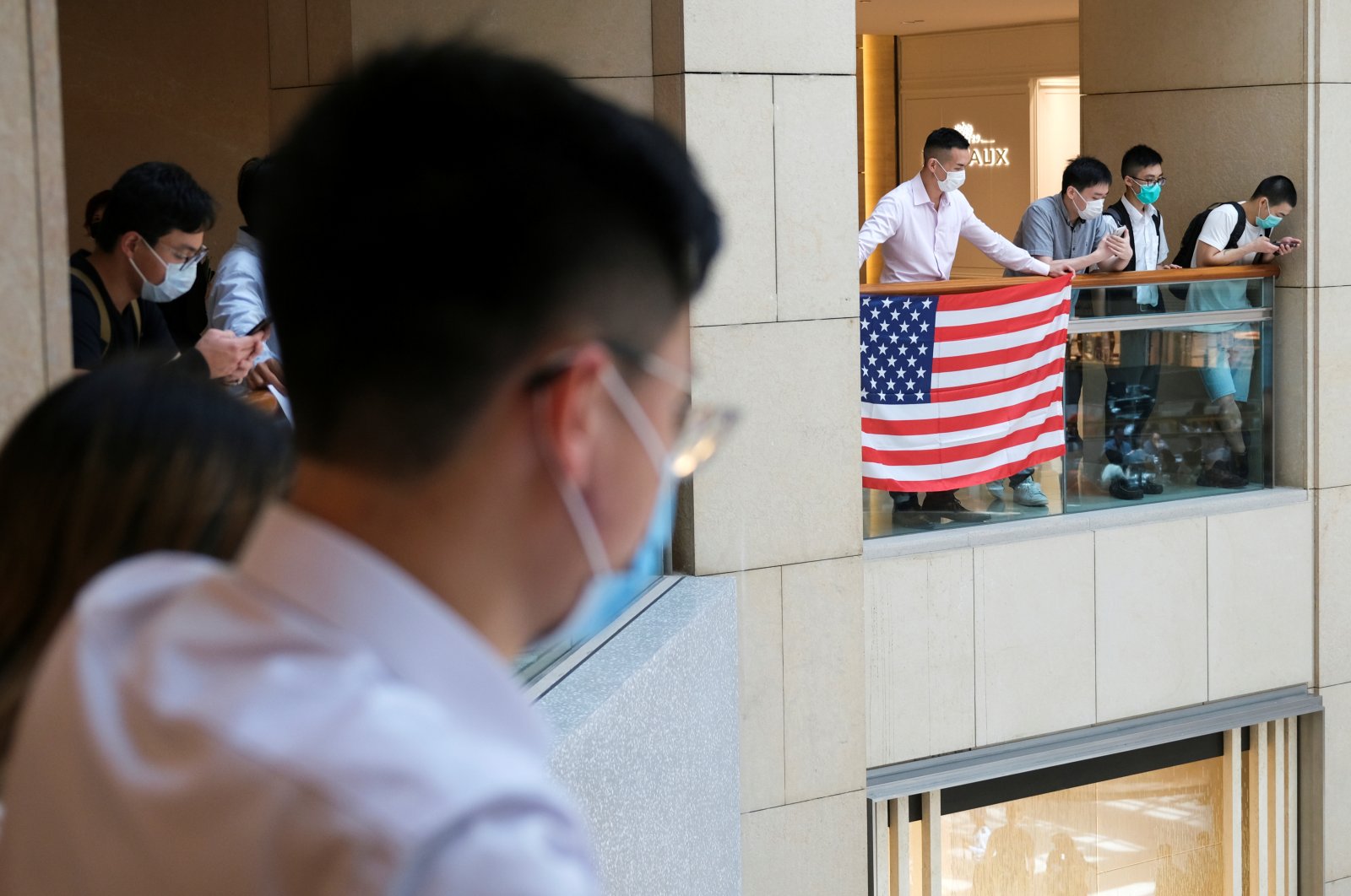 A pro-democracy demonstrator wearing a face mask holds a U.S. flag during a protest against new national security legislation, Hong Kong, June 1, 2020. (Reuters Photo)