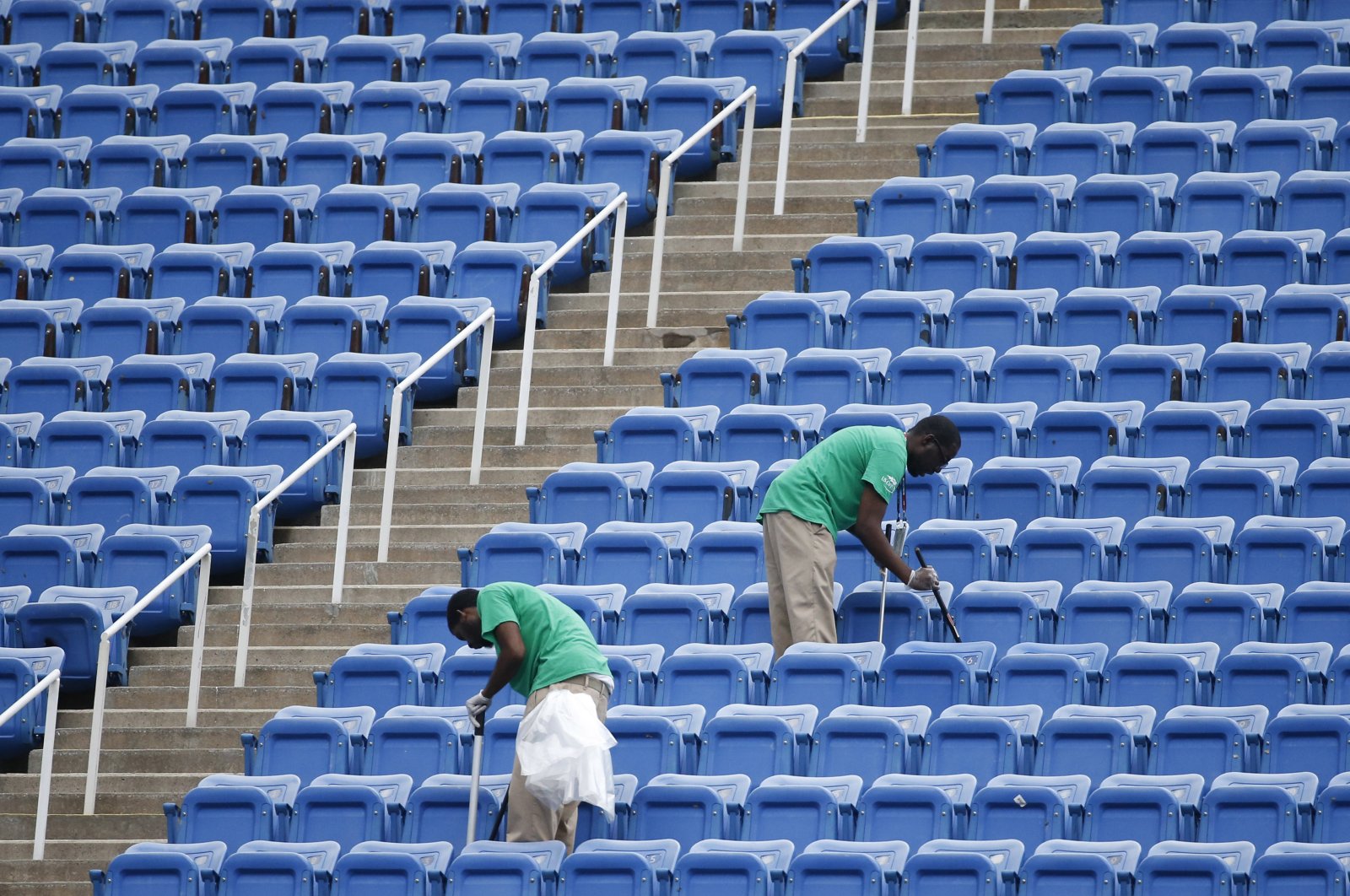 Workers clean the empty stands in Arthur Ashe Stadium after the women's semifinal matches were postponed because of rain at the U.S. Open tennis tournament in New York, U.S., Sept. 10, 2015. (AP Photo) 
