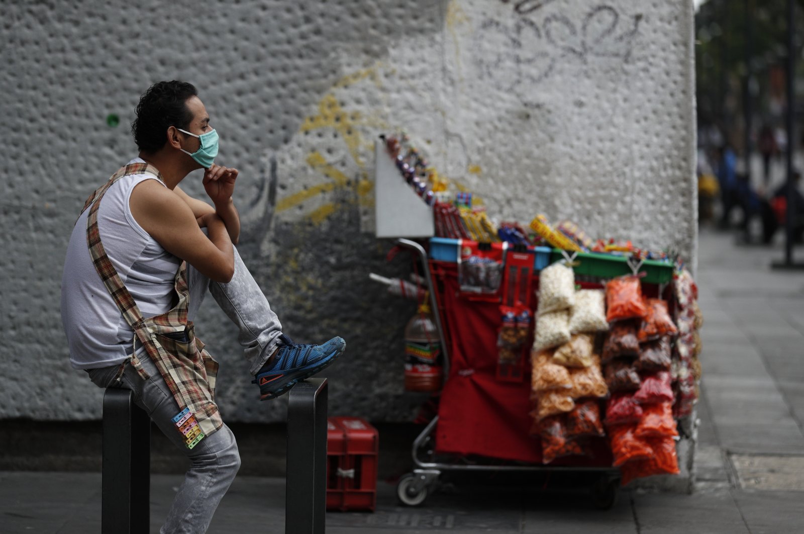 A snack vendor wears a mask as he waits for customers by his cart, in central Mexico City, Mexico, May 31, 2020. (AP Photo)