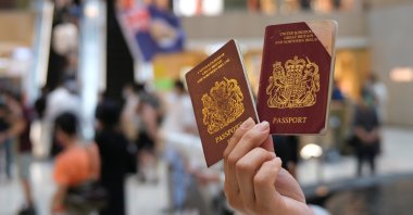 A pro-democracy demonstrator raises his British National Overseas (BNO) passports during a protest against new national security legislation in Hong Kong, China June 1, 2020. (Reuters Photo)