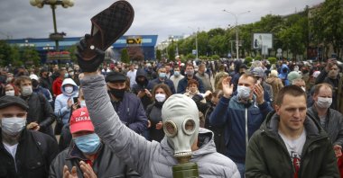 A man, wearing a gas mask to protect against the coronavirus, attends a rally to support for potential presidential candidates in the upcoming presidential elections in Minsk, Belarus, Sunday, May 31, 2020. (AP Photo)