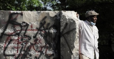 Robert Walker poses for a photograph on the remains of a Confederate memorial that was removed overnight in Birmingham, Ala., Tuesday, June 2, 2020. (AP Photo)