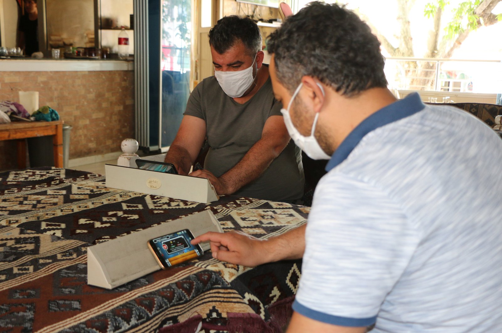 Customers play okey on their cellphones in Adıyaman, Turkey, June 2, 2020. (DHA Photo) 