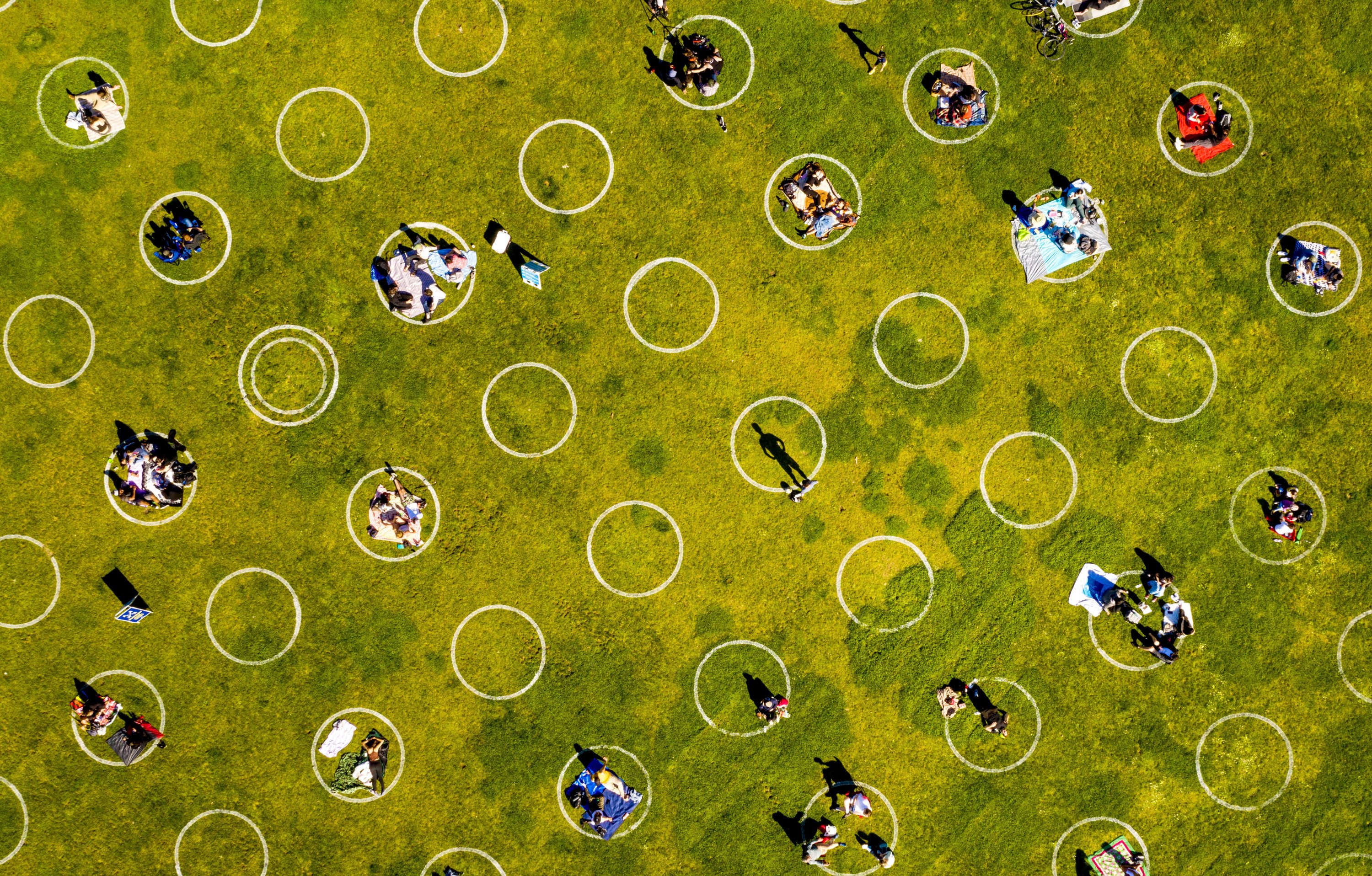 People in San Francisco's Dolores Park sit inside painted circles designed to help them keep a healthy distance, California, U.S., May 2, 2020. (AP Photo)