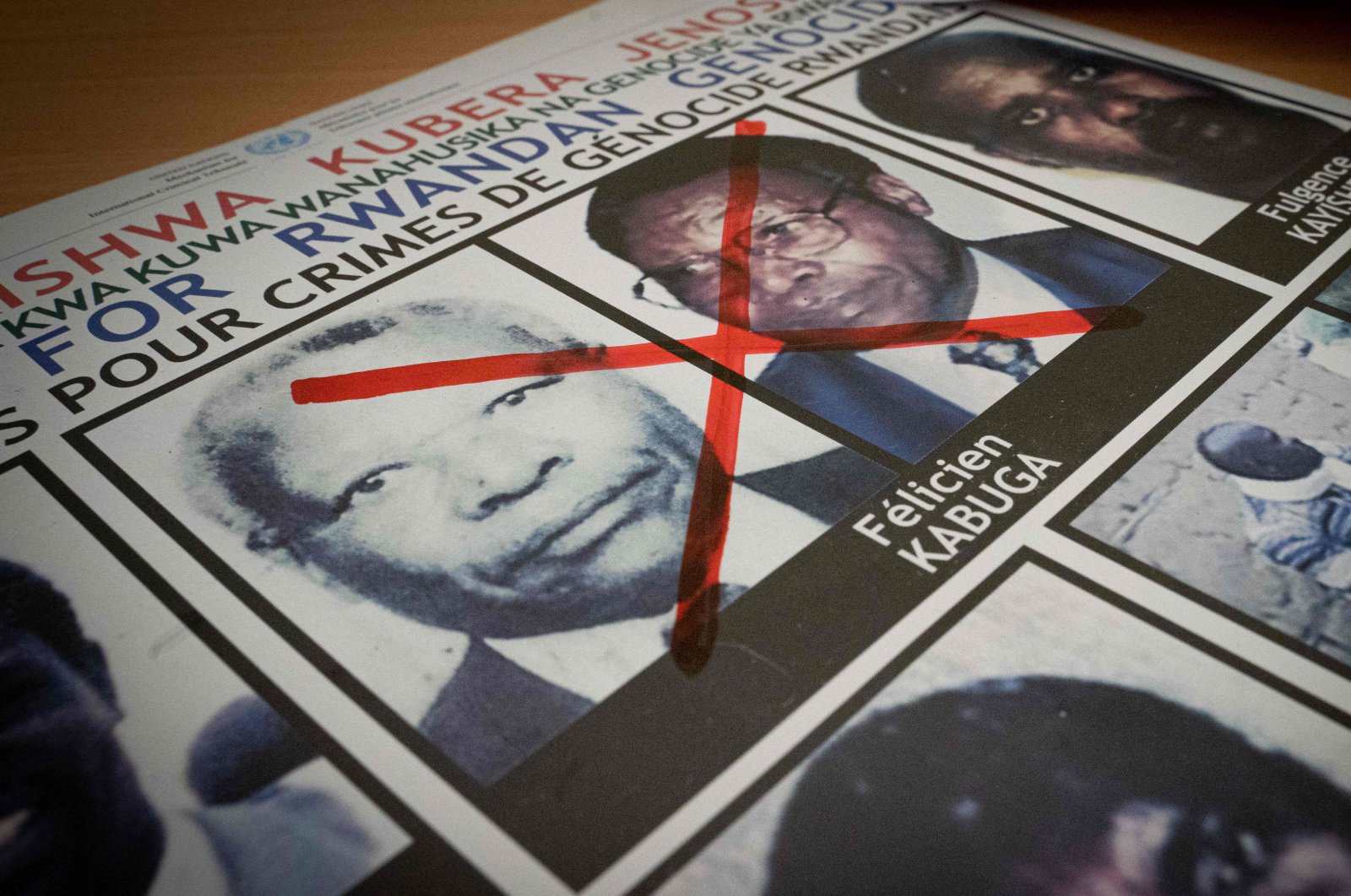 A photo shows a red cross drawn on the face of Felicien Kabuga, one of the last key suspects in the 1994 Rwandan genocide, on a wanted poster at the Genocide Fugitive Tracking Unit office in Kigali, Rwanda, May 19, 2020. (AFP Photo)