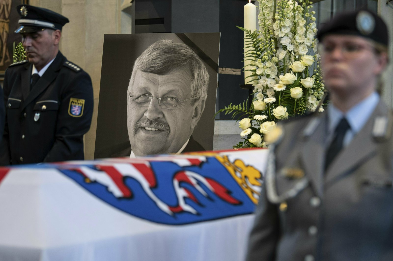 In this file photo a picture of Walter Luebcke stands behind his coffin during the funeral service in Kassel, Germany, June 13, 2019. (AP Photo)